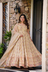 Woman in a beige, embroidered Anarkali gown.