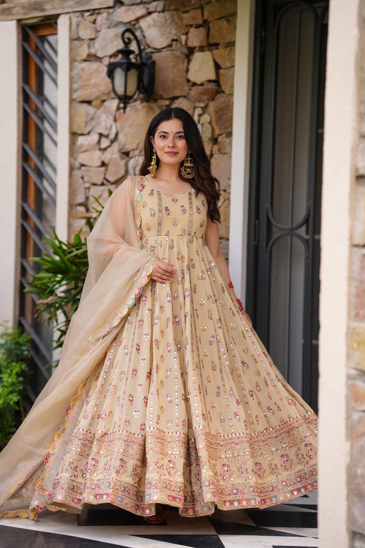Woman in a beige, embroidered Anarkali gown.